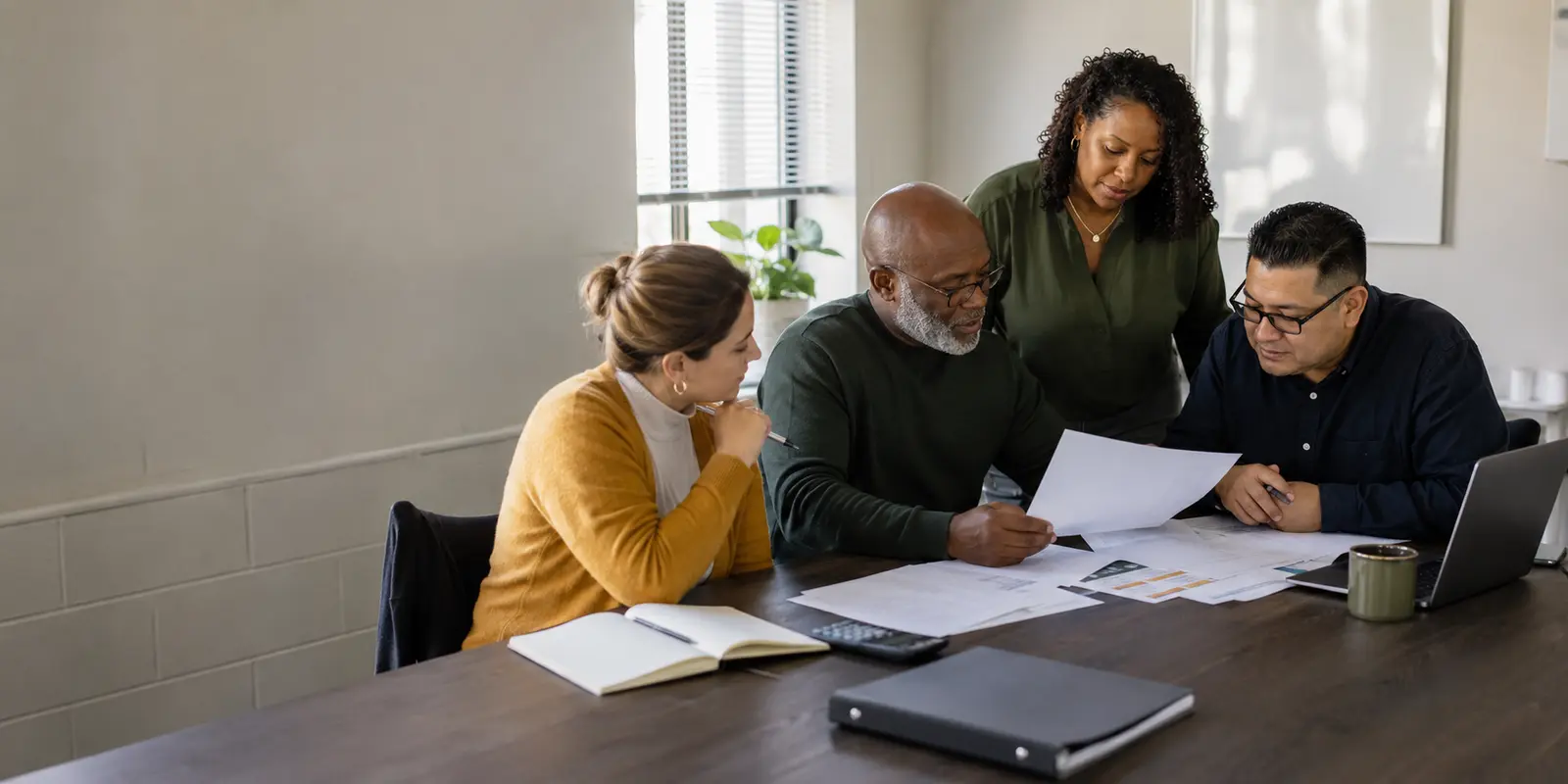 A nonprofit leadership team reviewing workplans and financial documents together