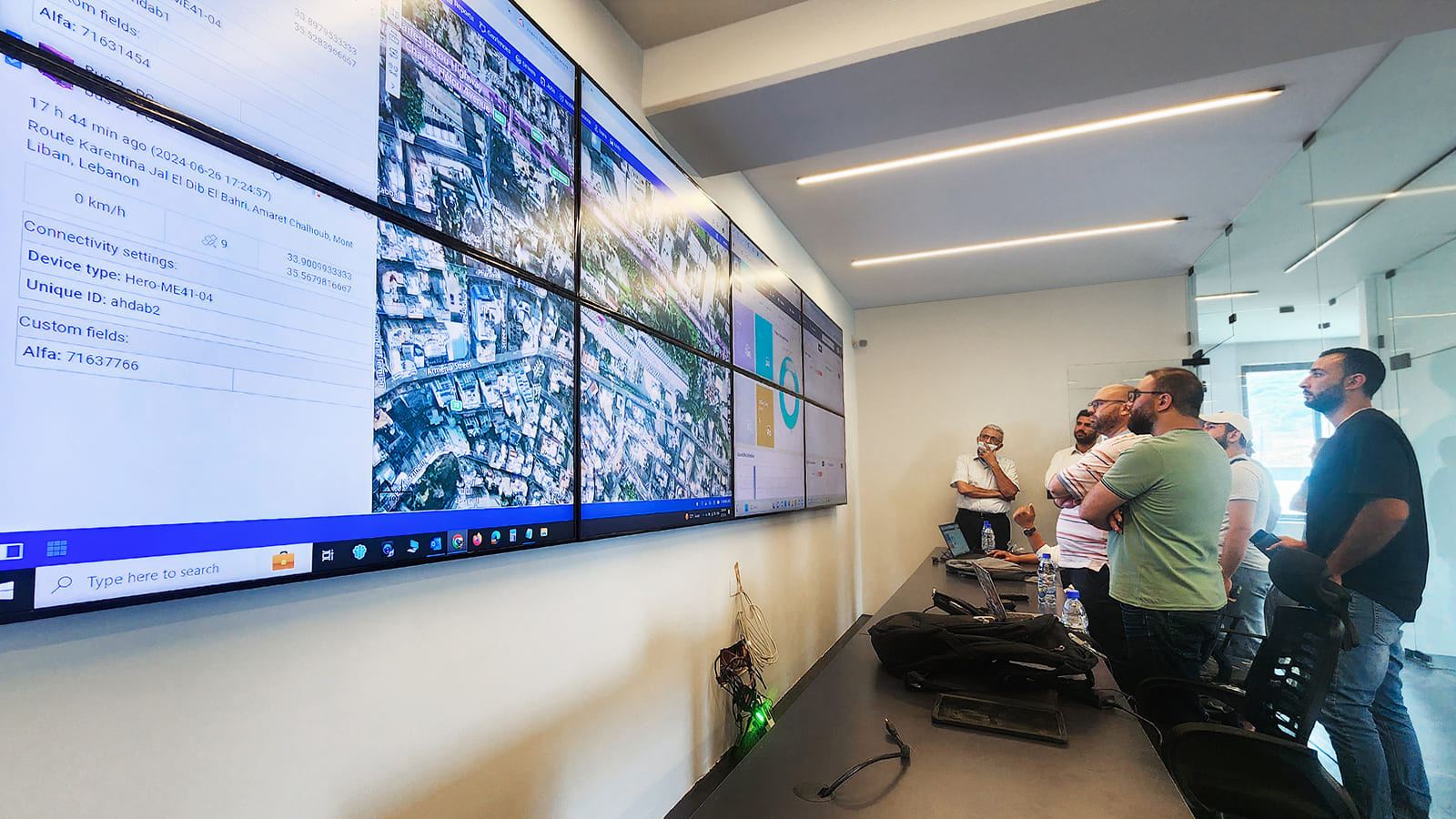 A team reviewing live data dashboards on a wall of screens