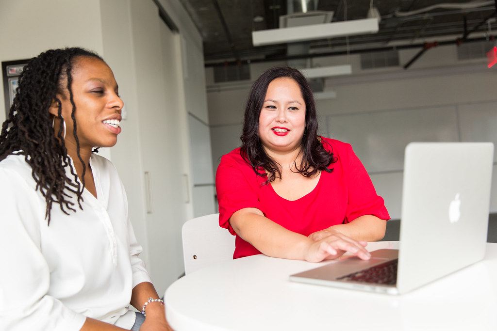 Two people collaborating at a laptop in a modern workspace